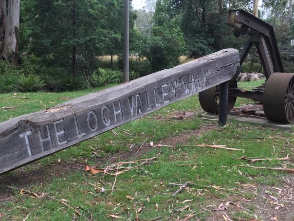 An old beam with the words The Loch Valley Walk carved in the side