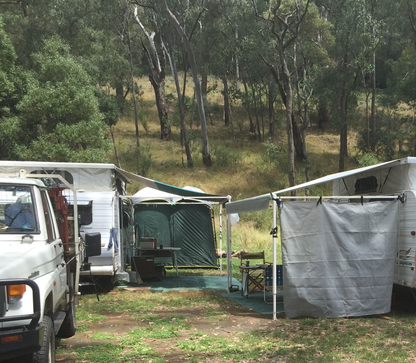 Two caravans set up in a grassy campground