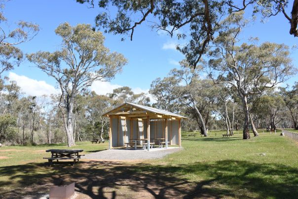 A tin picnic shelter with two picnic tables