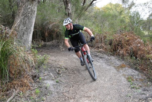 A man riding a mountain bike around a trail corner