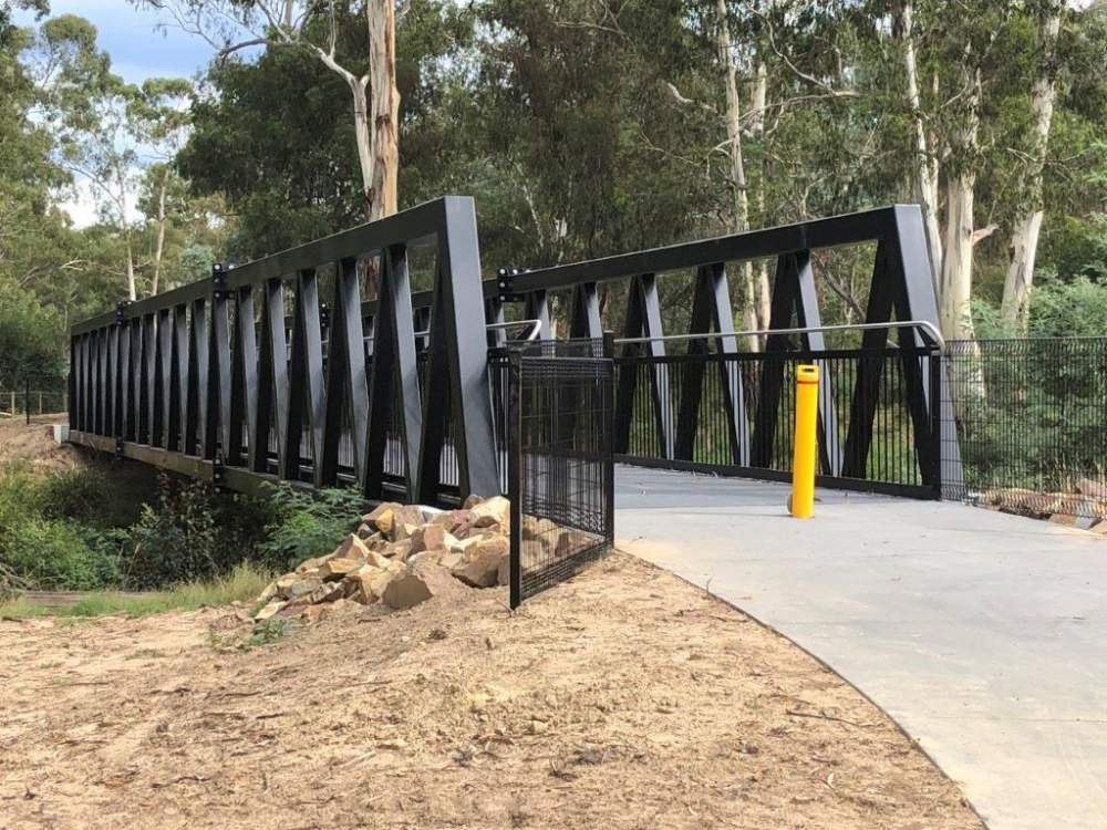 divided trail showing bridge, yellow trail divider pole and safety rails both sides