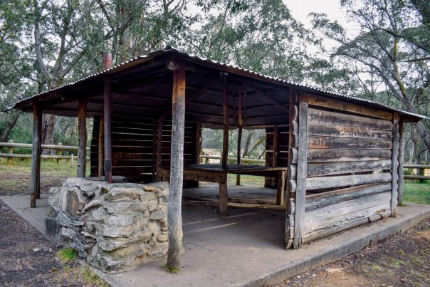 A large wooden picnic shelter among trees