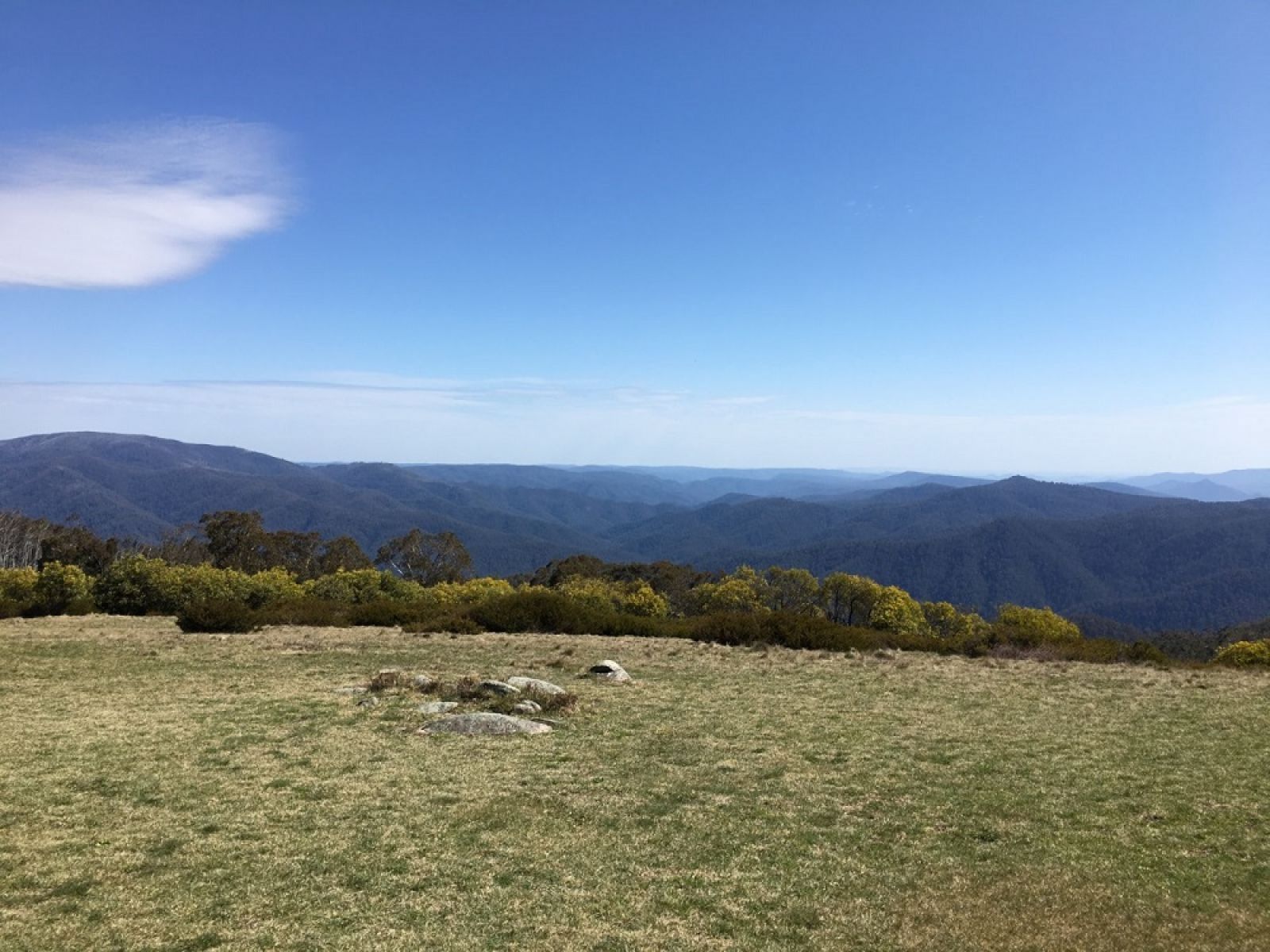 A grassy area overlooking the surrounding mountains. 