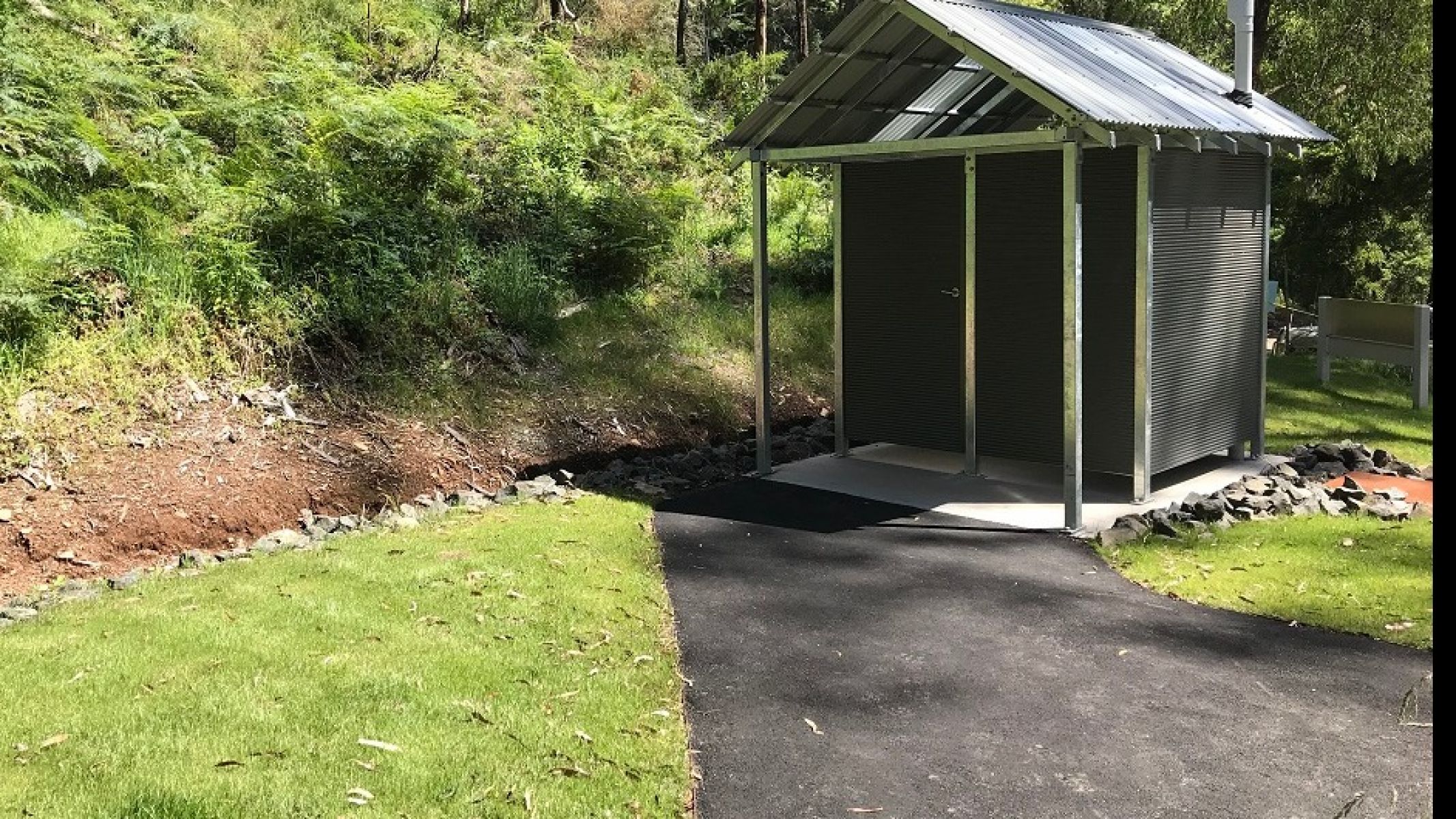 Toilet with wide flat gravel path in foreground