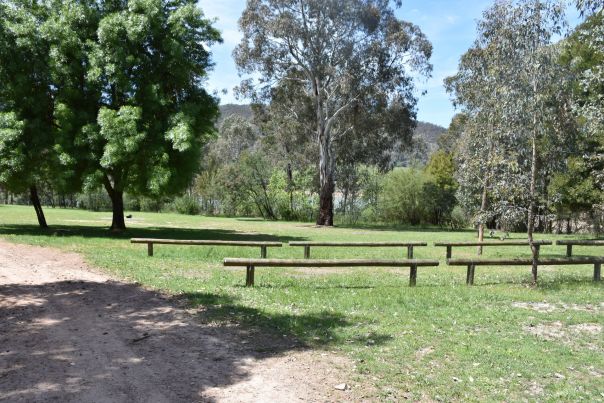 A grassy campground with several low wooden barriers