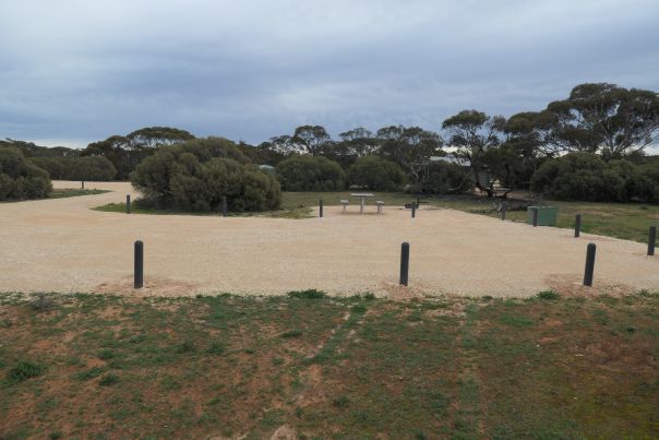 A large dirt area leading up to a picnic table.