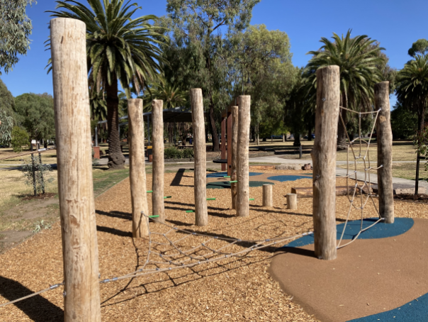 Climbing frame and poles with trees in background