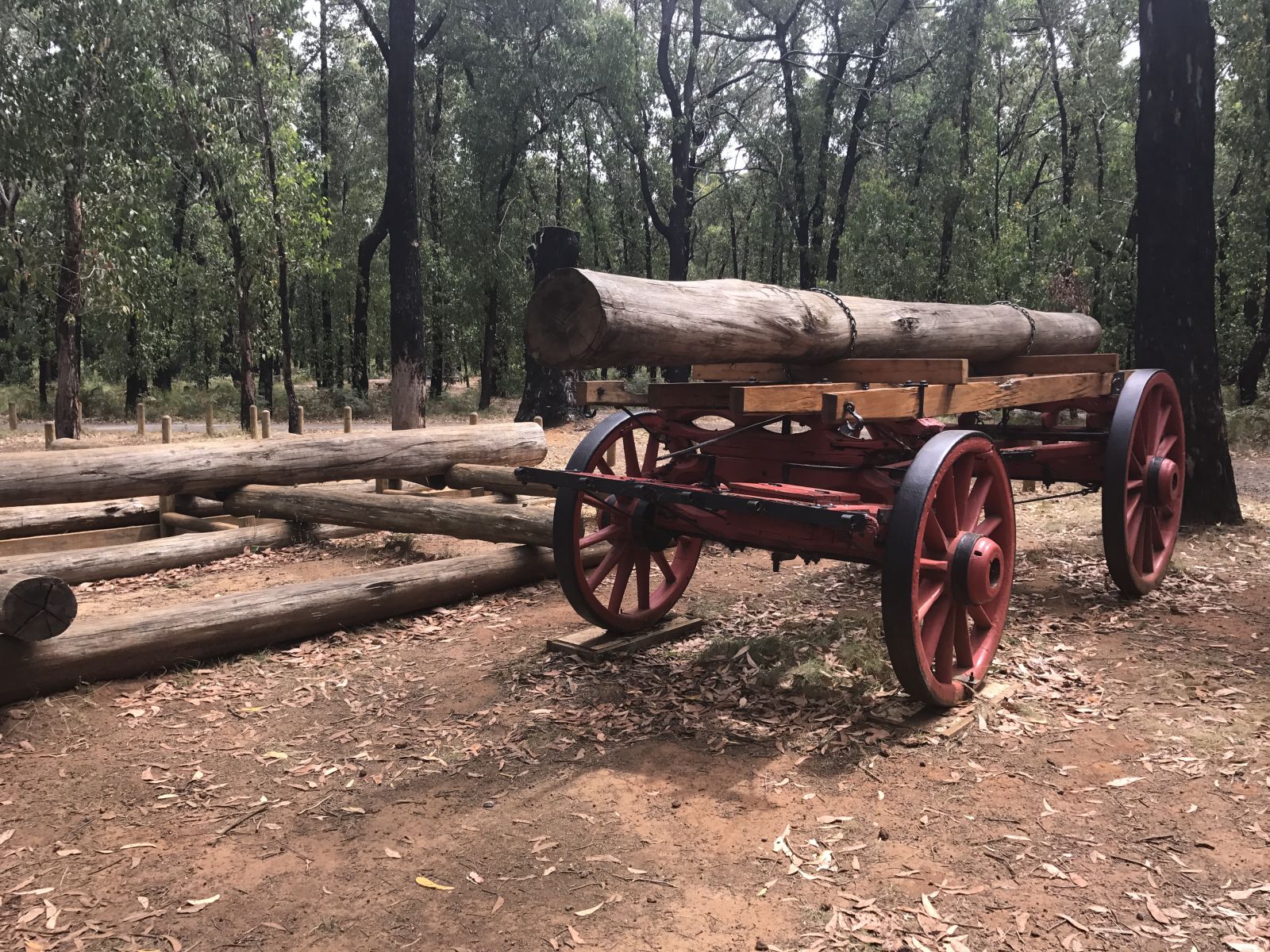 A wooden wagon with a large log as its load