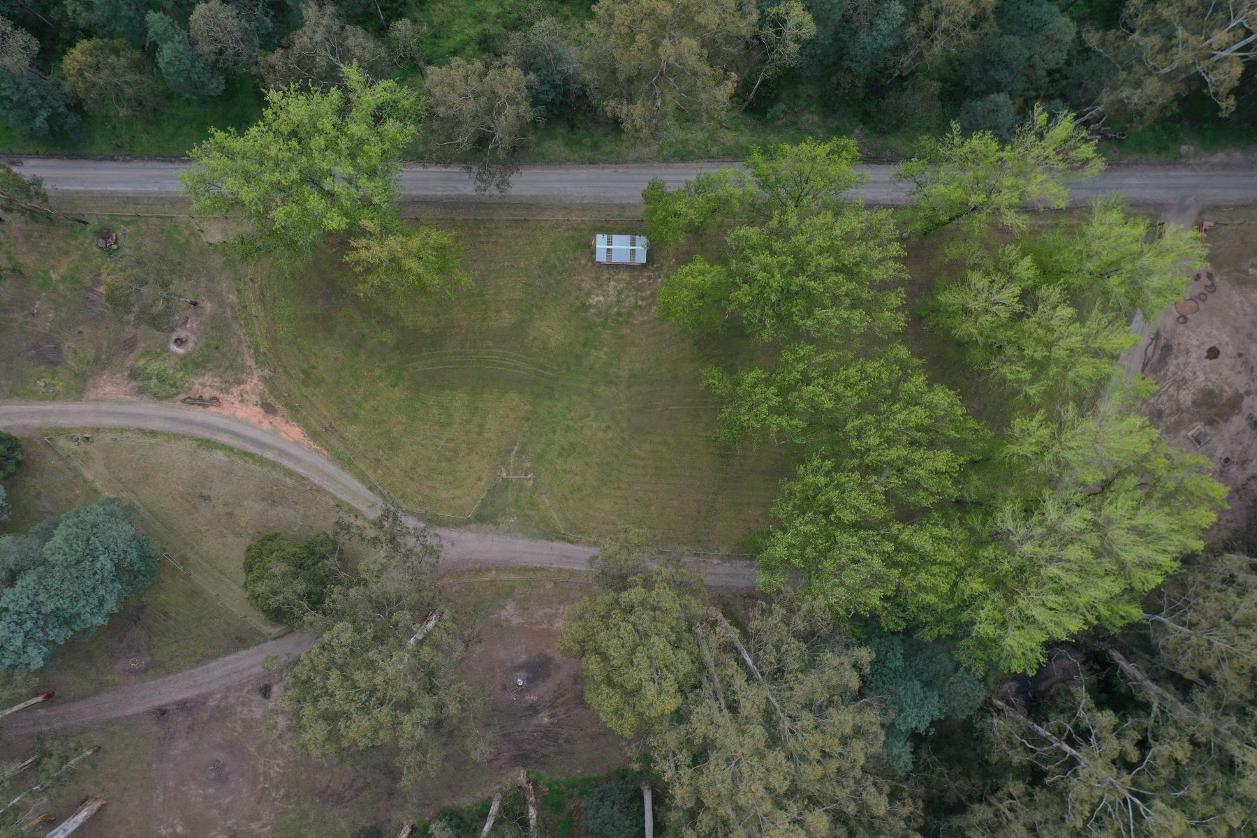 An image taken from a drone above Poplars Reserve, showcasing the large camping area surrounded by native trees 