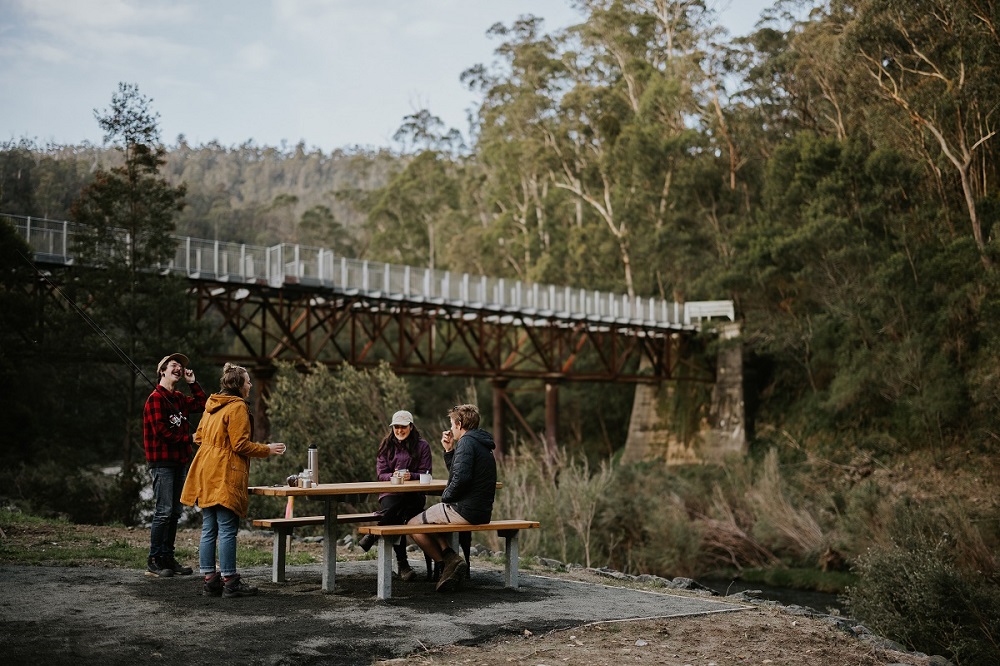 People having a picnic by the river at Bruntons Bridge   