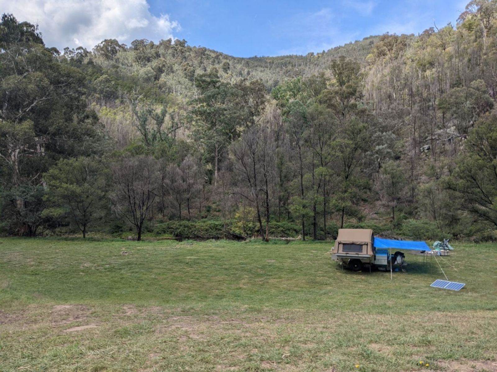A caravan in an open grassy campsite. 
