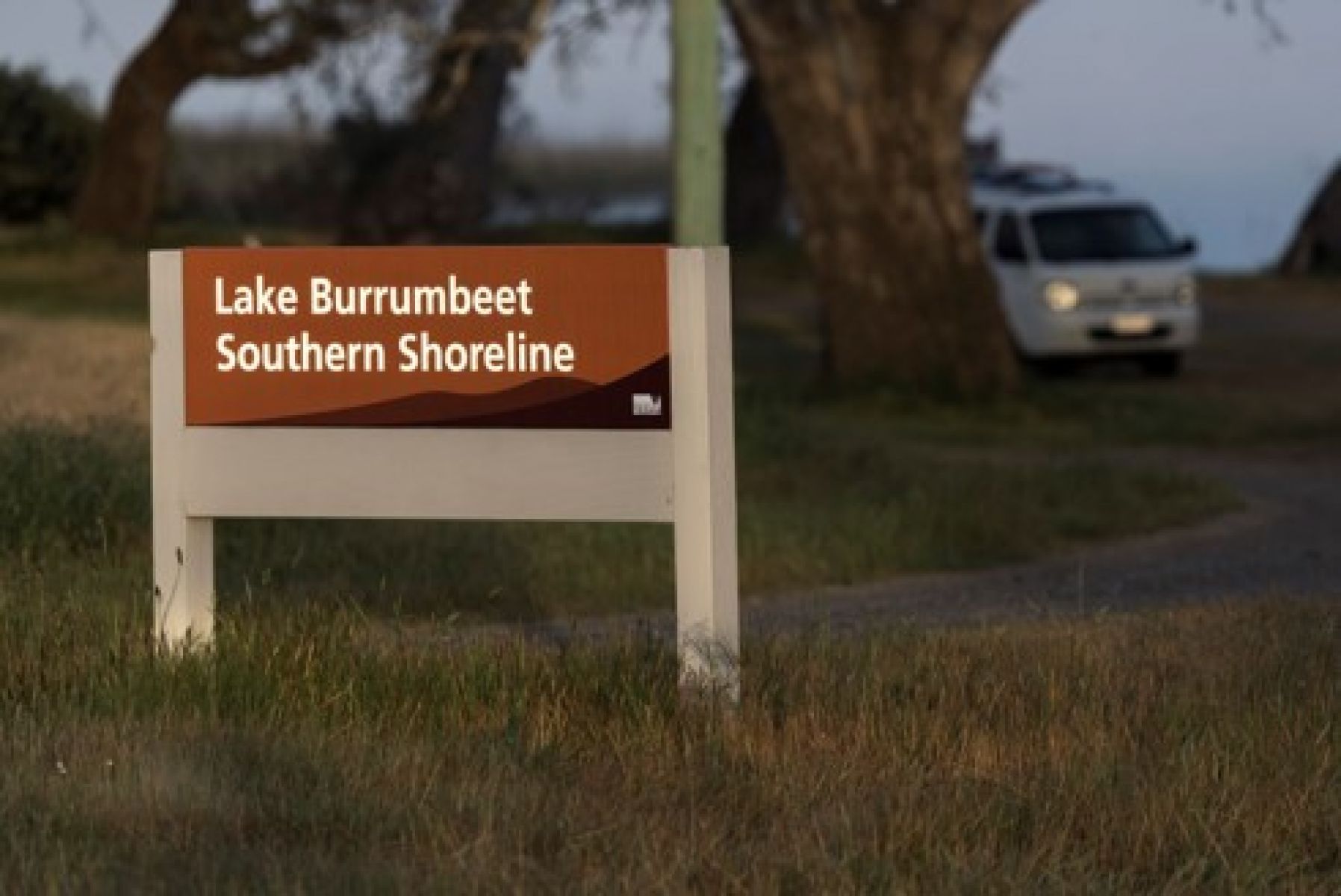A white van drives towards a sign for Lake Burrumbeet