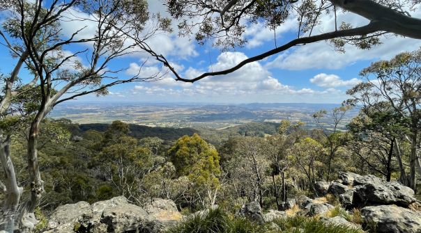 A view from a mountain edge of valleys below and hills in the distance