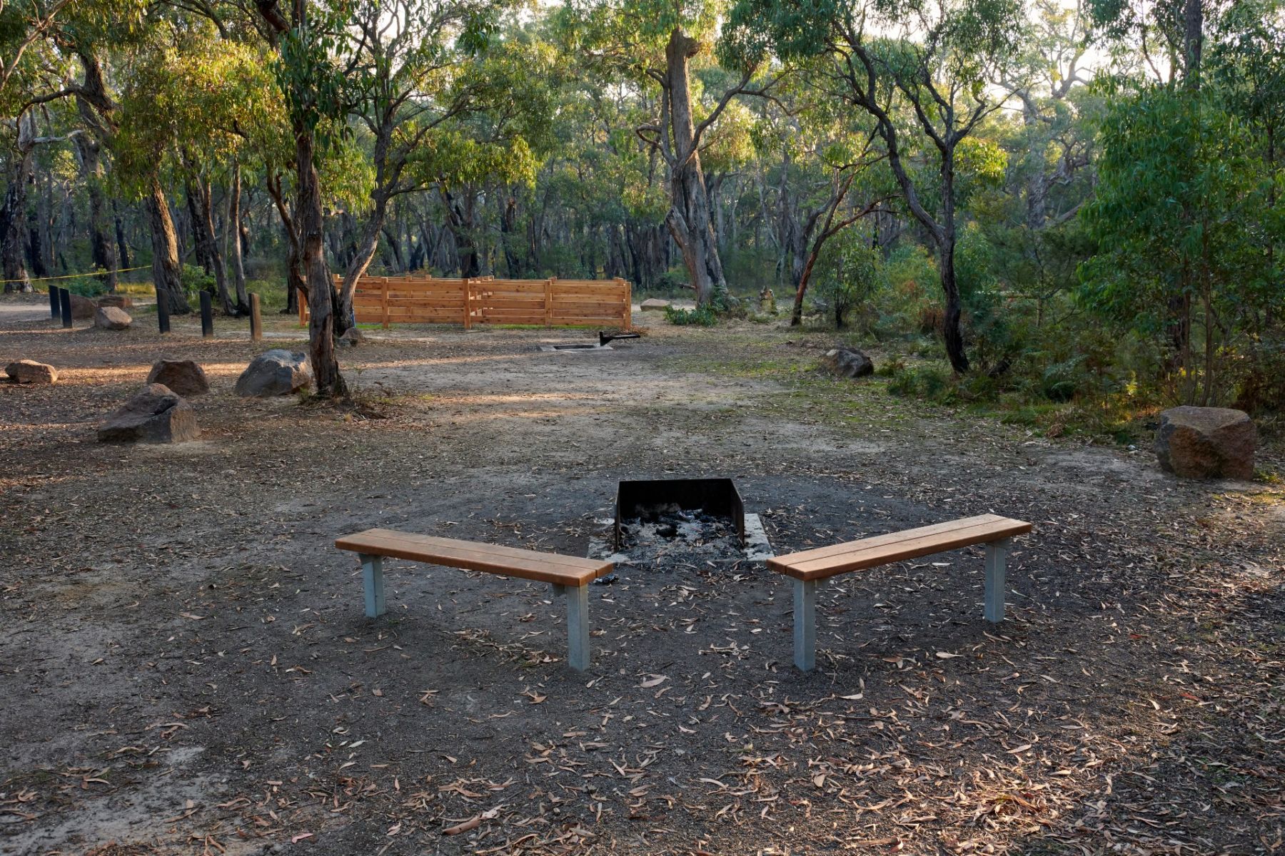 Two benches in front of a firepit in the campground