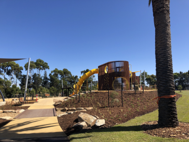 Playscape in centre of architectured area, sail cover on left