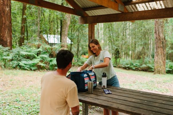 Two people at a table under a shelter