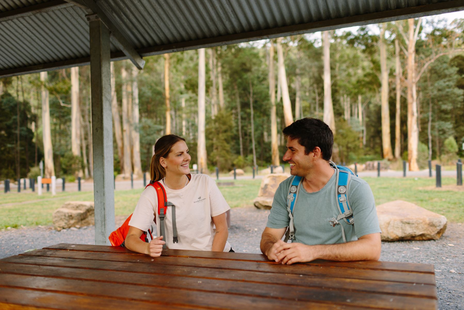 Two people sitting at a table under shelter