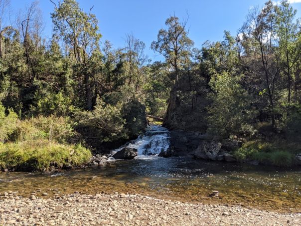 Water flowing through a cut out section of rock into a river