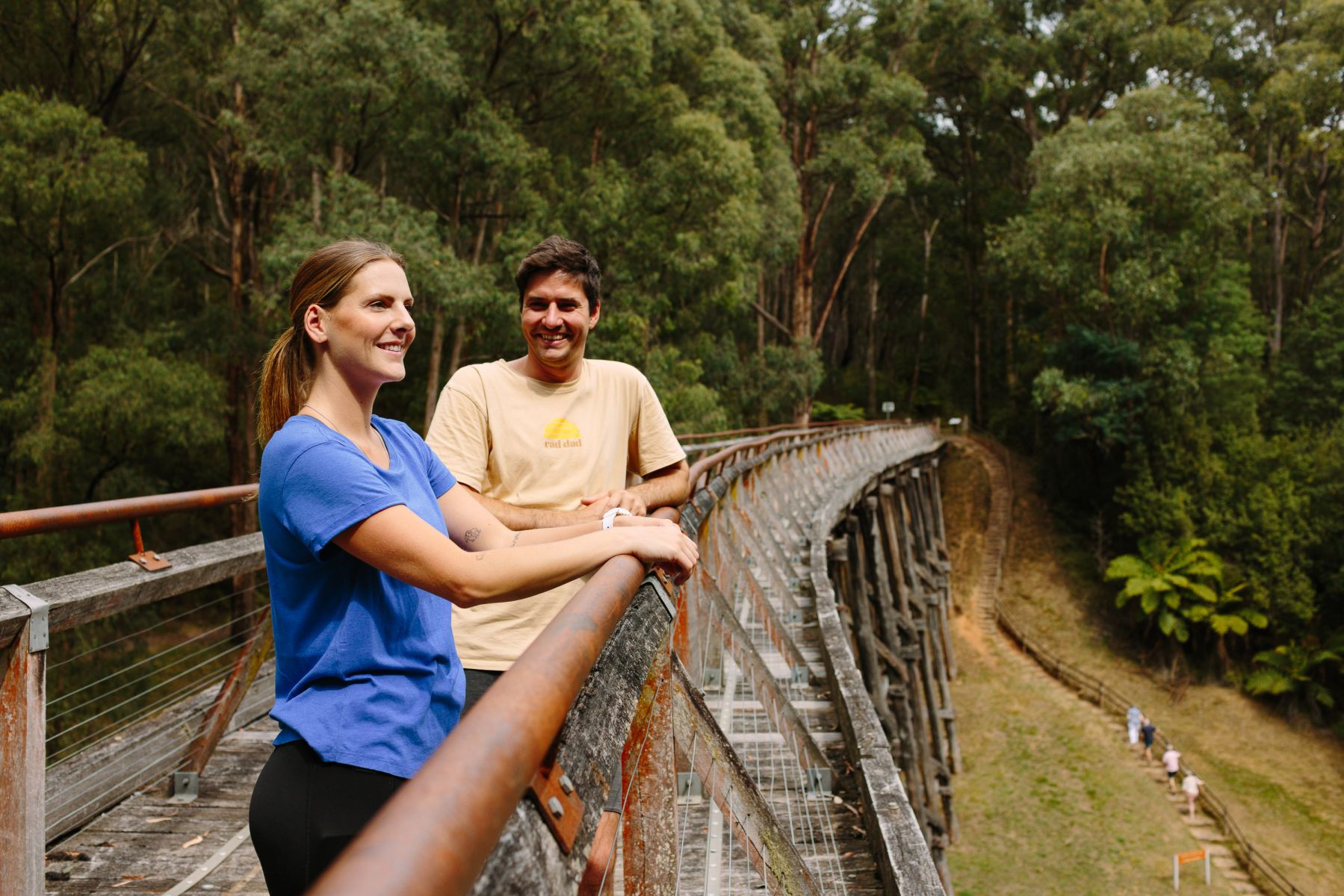 Two people standing on a old wooden trestle bridge