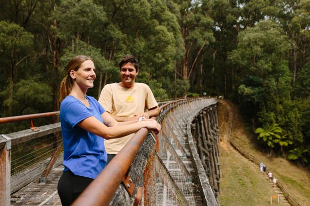 Two people standing on a old wooden trestle bridge