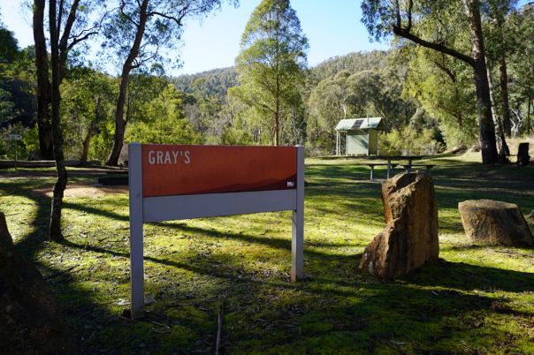 A campground sign in a grass clearing
