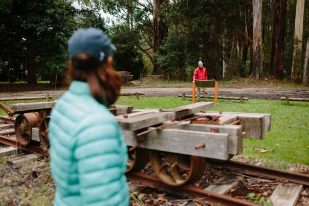 Two people looking at historical artefacts in the forest. 