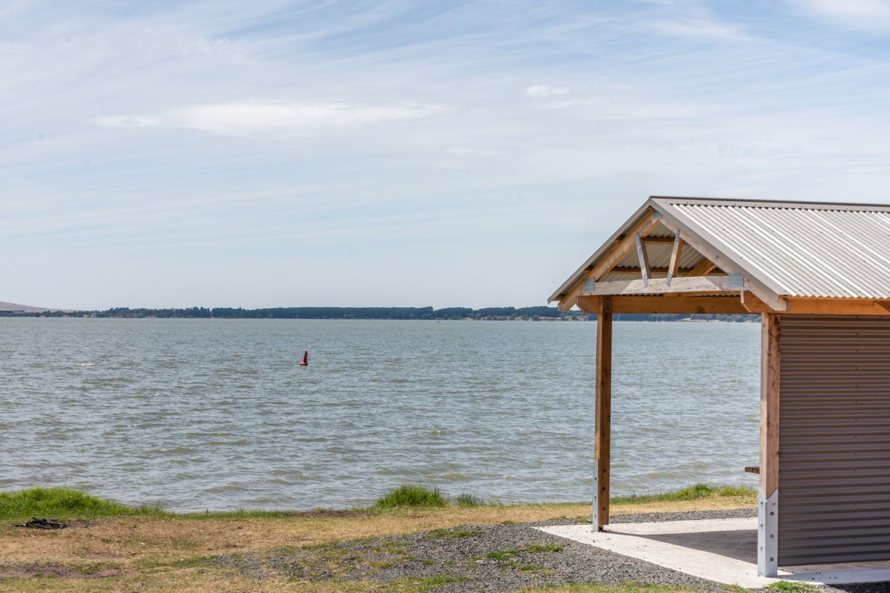 A picnic shelter looking out over a lake.