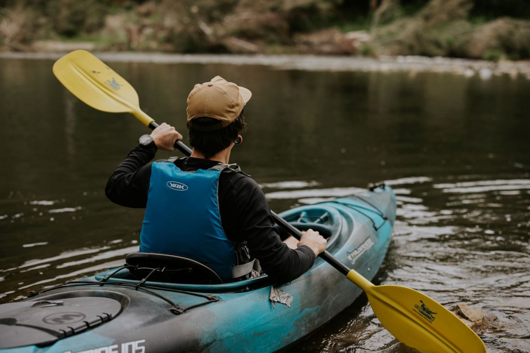 A person wearing a life jack paddling on the river