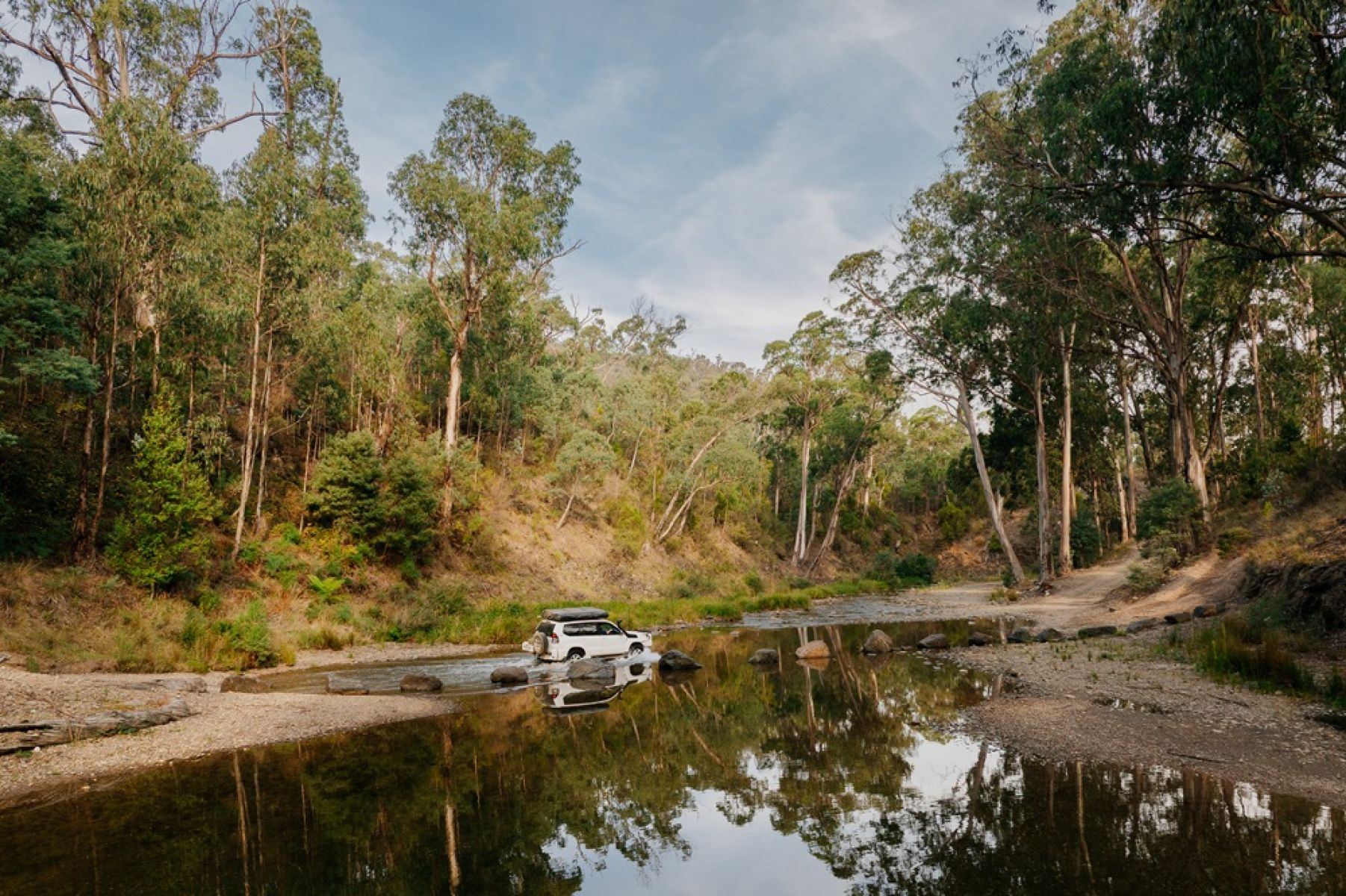 A 4WD vehicle driving through a river