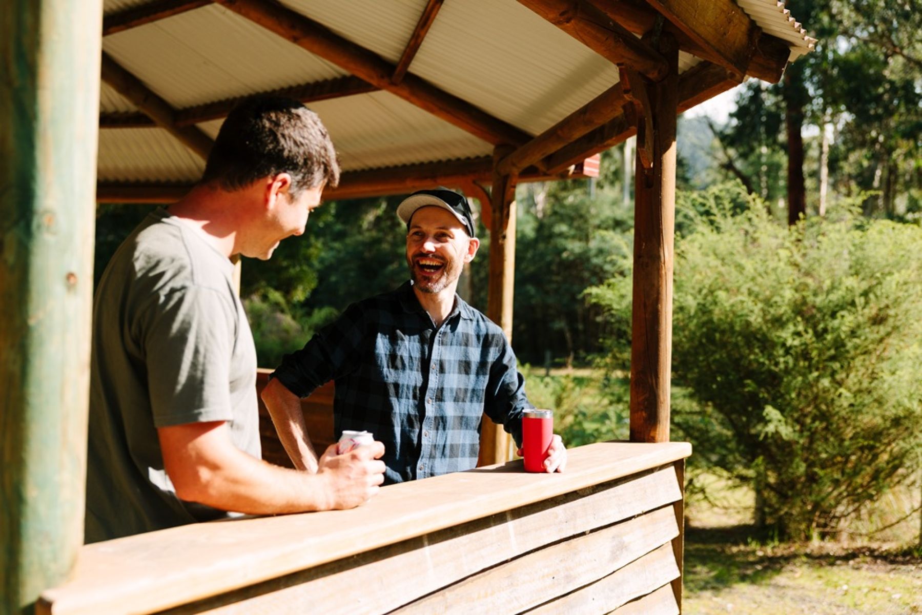 Two people standing under a shelter