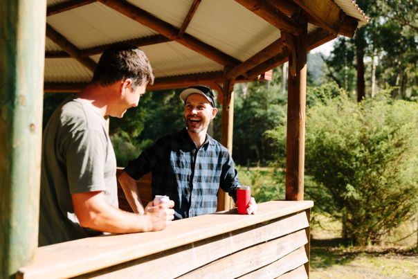 Two people standing under a shelter