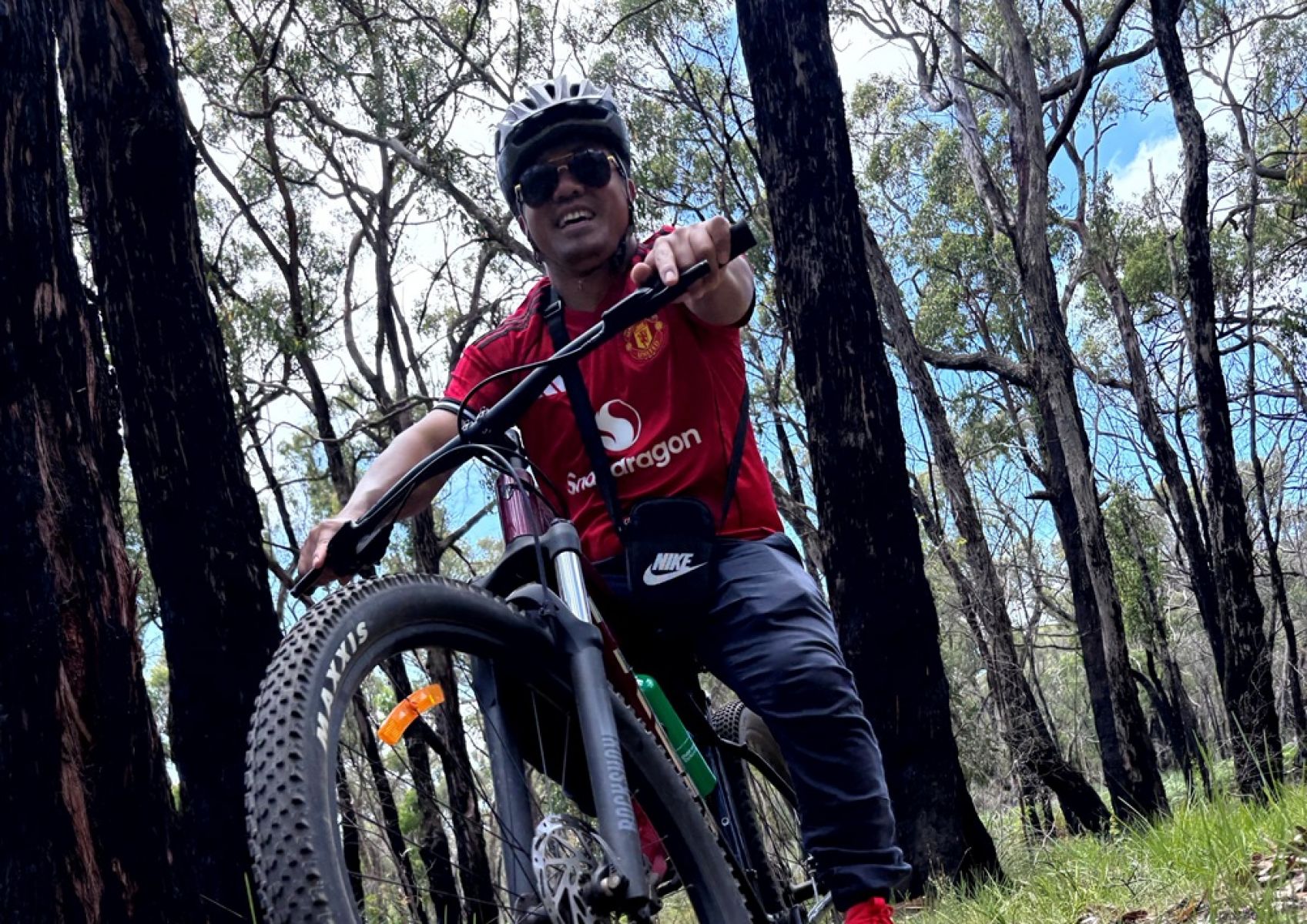A young person on a mountain bike surrounded by forest